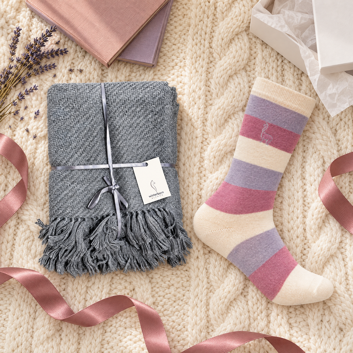 Alpaca lap blanket and socks gift set on a cable knit throw