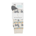 Cream alpaca socks with an alpaca pattern in Winterborn packaging