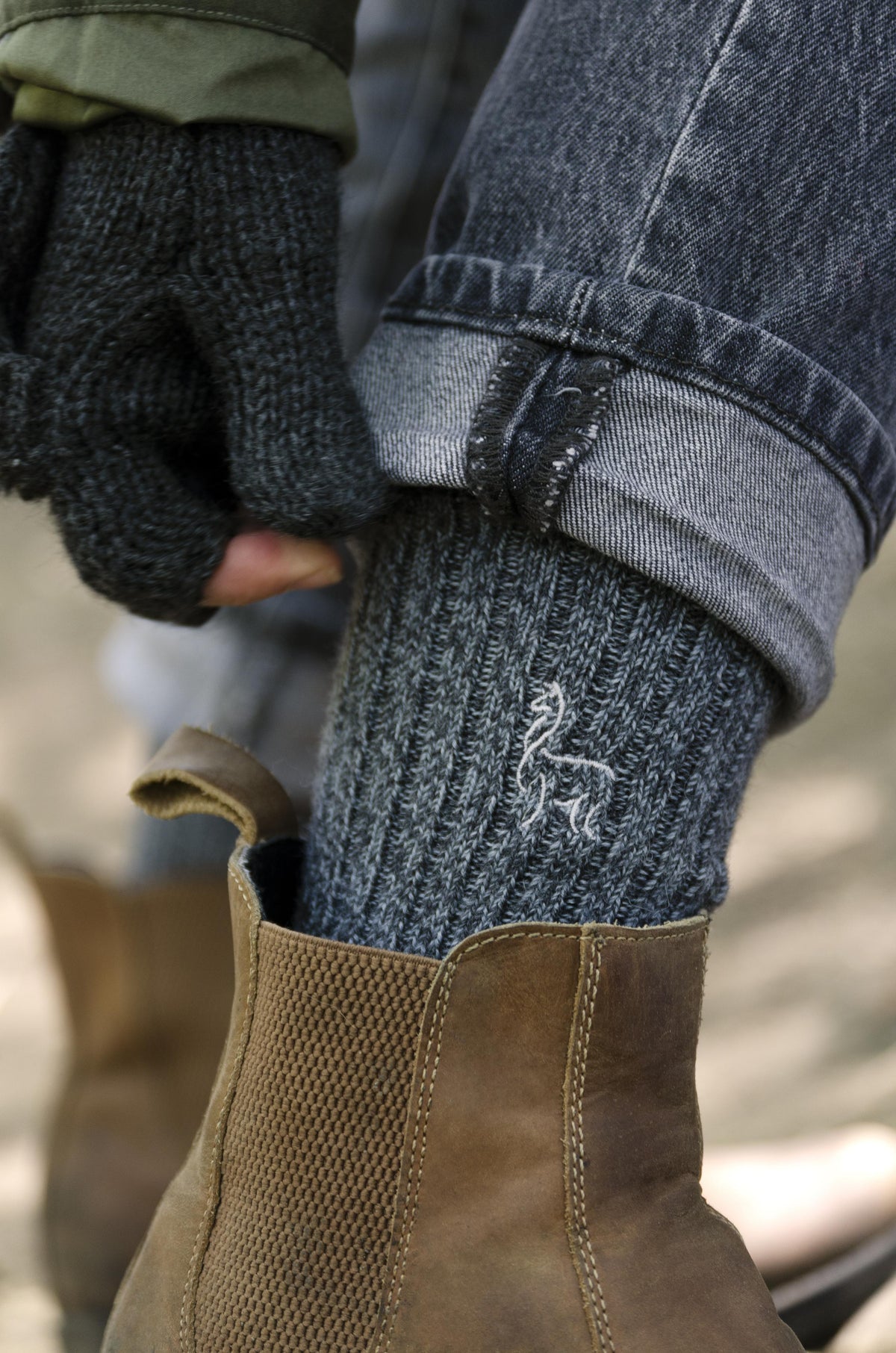 Grey alpaca sport sock pulled up over jeans into a boot